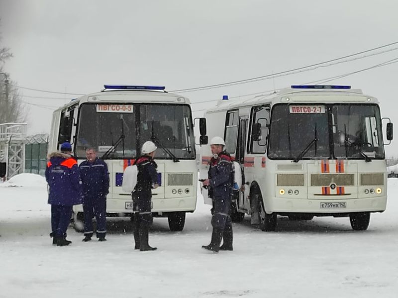 &copy; Reuters. Varios trabajadores de servicios de emergencias junto a dos autobuses durante la operación de rescate en la mina de carbón de Listvyazhnaya tras un incendio, en la región de Kemerovo, Rusia, el 25 de noviembre de 2021. Ministerio de Emergencias de Rusi