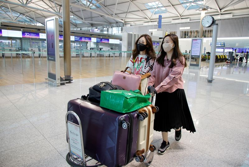 &copy; Reuters. Kim Ji-eun and Lee Hyun-joo, fans of K-pop boy band BTS, walk at the Incheon International Airport in Incheon, South Korea, November 25, 2021. Picture taken November 25, 2021.  REUTERS/ Heo Ran