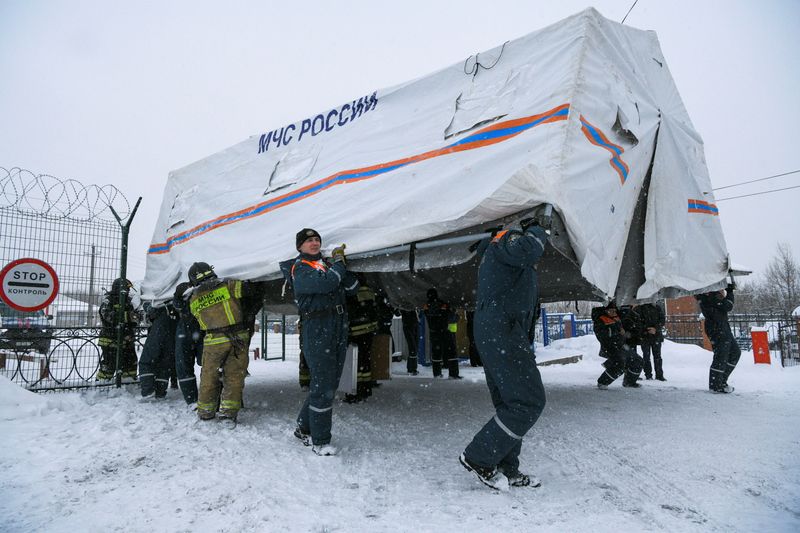 © Reuters. Specialists of Russian Emergencies Ministry carry a tent during a rescue operation following a fire in the Listvyazhnaya coal mine in the Kemerovo region, Russia, November 25, 2021. REUTERS/Alexander Patrin     