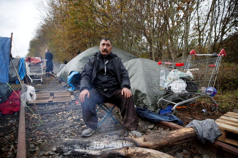 &copy; Reuters. مهاجر يجلس في مخيم في بلدة دونكيرك الساحلية بفرنسا يوم الخميس. تصوير: جوهانا جيرون - رويترز. 