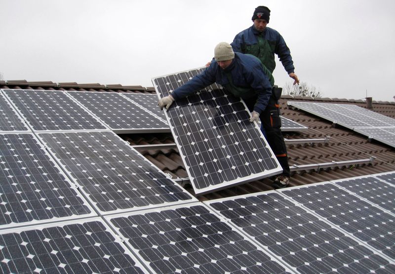 &copy; Reuters. FILE PHOTO: Workers install solar panels on the roof of a kindergarten in the town of Falkensee near Berlin December 10, 2008.  REUTERS/Erik Kirschbaum/File Photo