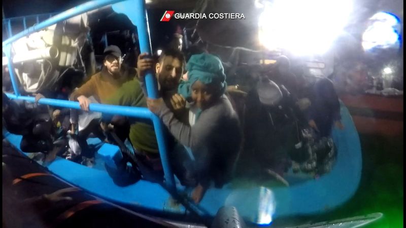 &copy; Reuters. مهاجرون يصعدون على متن سفينة لخفر السواحل الإيطالي من قارب في البحر المتوسط يوم الخميس. صورة لرويترز محظور إعادة بيعها أو وضعها في أرشيف.