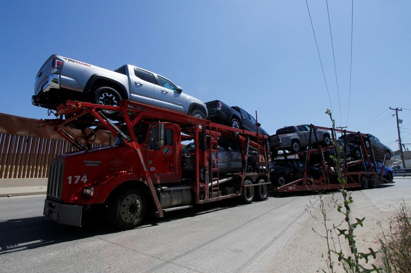 © Reuters. FILE PHOTO: A carrier trailer transports Toyota vehicles for delivery while queuing at the border for customs control to cross into the U.S., at the Otay border crossing in Tijuana, Mexico June 30, 2020. REUTERS/Jorge Duenes