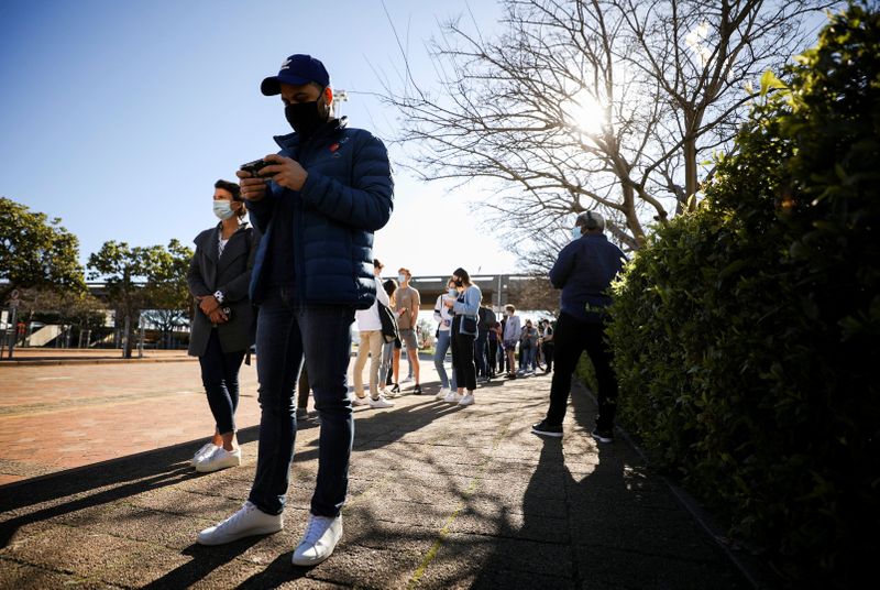 © Reuters. FILE PHOTO: People queue outside a coronavirus disease (COVID-19) vaccination centre as the country opens vaccinations for everyone 18 years old and above in Cape Town, South Africa, August 20, 2021.  REUTERS/Mike Hutchings/File Photo