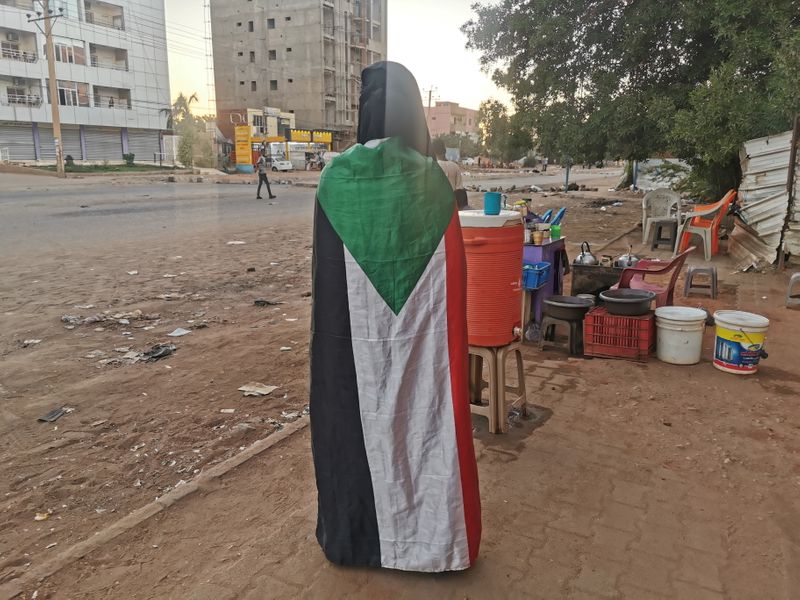 © Reuters. A person wears a Sudanese flag during a protest, in Khartoum, Sudan, November 25, 2021. REUTERS/El Tayeb Siddig