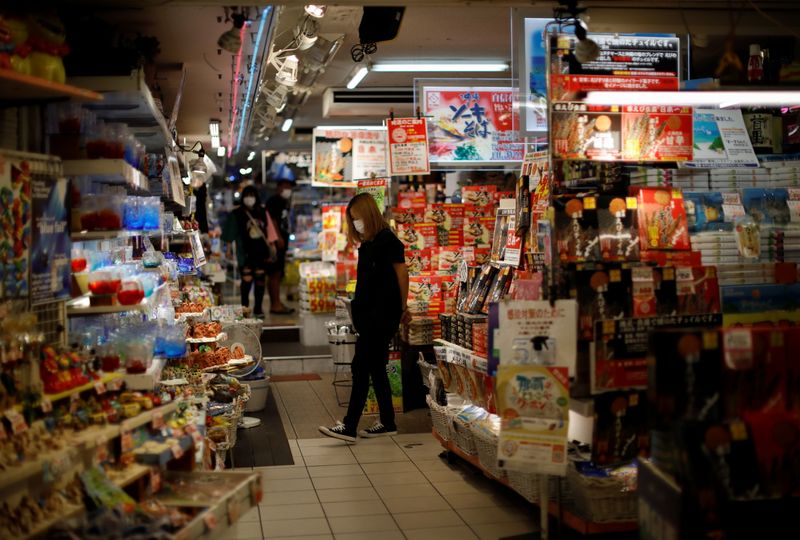 &copy; Reuters. FILE PHOTO: Shoppers wearing protective face masks, amid the coronavirus disease (COVID-19) pandemic, are seen inside a souvenir shop along the Kokusai-dori in the prefectural capital Naha, on the southern island of Okinawa, Okinawa prefecture, Japan, Oct