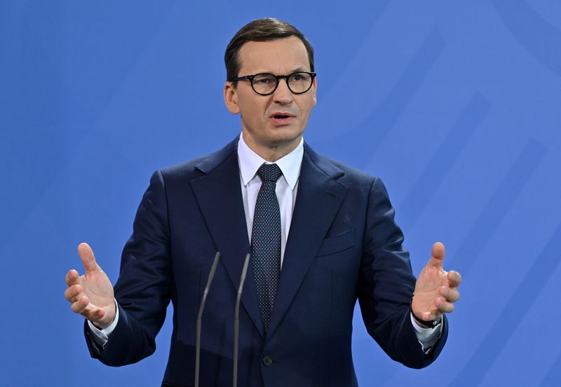 &copy; Reuters. ポーランドのモラウィエツキ首相は２５日、石油、ガス、電力に対する課税率を引き下げるとともに、家計に現金を支給すると発表した。写真は、ベルリンで会見する同首相。２０２１年１