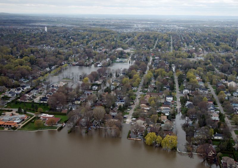 © Reuters. カナダの環境対策監視機関は２６日に公表した報告書で、トルドー政権の気候変動対策は一貫しておらず、不十分だと批判した。写真は、水害で水浸しになったケベック州の住宅地。２０１７年５月１１日に撮影。（２０２１年　ロイター／Christinne Muschi）