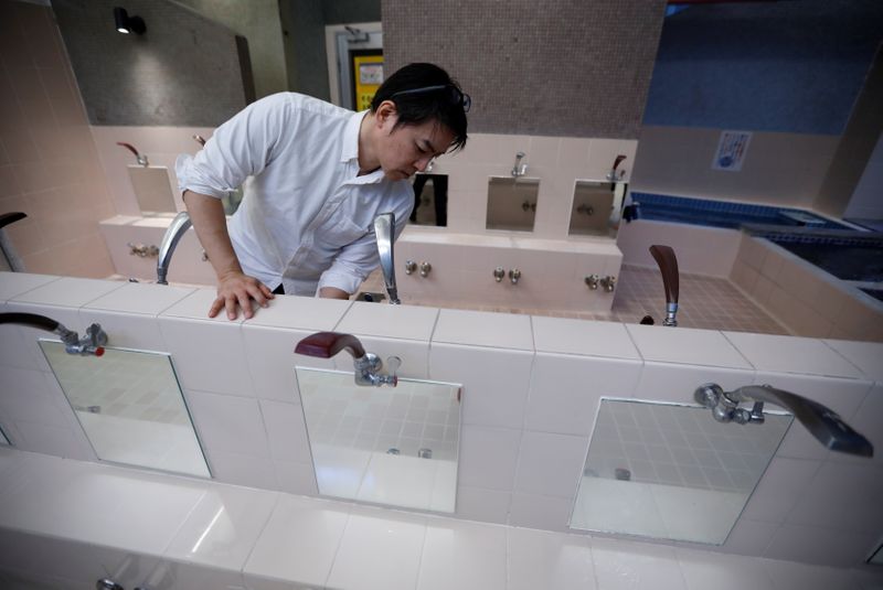 &copy; Reuters. Tokuji Ito (53), the proprietor of Japanese public bathhouse (or sento) 'Dai-ni Takara-yu', prepares to open his facility in Tokyo, Japan November 25, 2021. Picture taken November 25, 2021.  REUTERS/Issei Kato