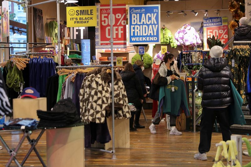 &copy; Reuters. Customers carry clothes at a store on "Black Friday" in the West End shopping district of London, Britain, November 26, 2021. REUTERS/May James