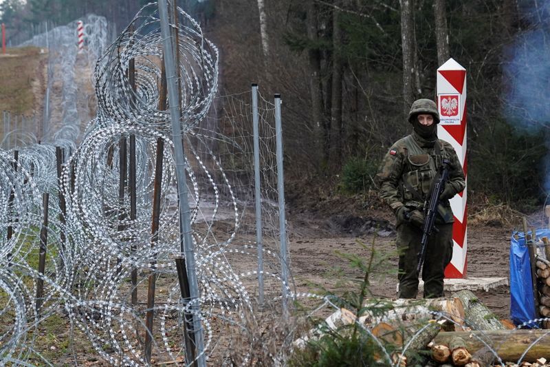 &copy; Reuters. A Polish border guard stands guard near the Belarus border near Kapciamiestis, Lithuania November 26, 2021. REUTERS/Janis Laizans