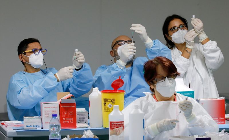 &copy; Reuters. Diversi operatori sanitari preparano dosi per vaccinazioni a Napoli. REUTERS/Ciro De Luca