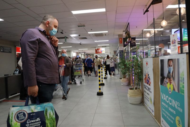 &copy; Reuters.  Un uomo indossa una mascherina protettiva e guarda un poster per la vaccinazione contro il coronavirus a Bruxelles, Belgio. 30 agosto 2021 REUTERS/Bart Biesemans