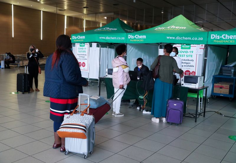 © Reuters. Passengers queue to get a PCR test against the coronavirus disease (COVID-19) before traveling on international flights, at O.R. Tambo International Airport in Johannesburg, South Africa, November 26, 2021. REUTERS/Sumaya Hisham