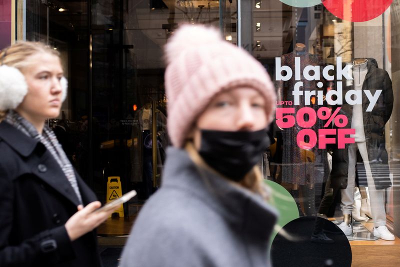 © Reuters. People walk along a store with sales signage during Black Friday sales in the Manhattan borough of New York City, New York, U.S., November 26, 2021. REUTERS/Jeenah Moon