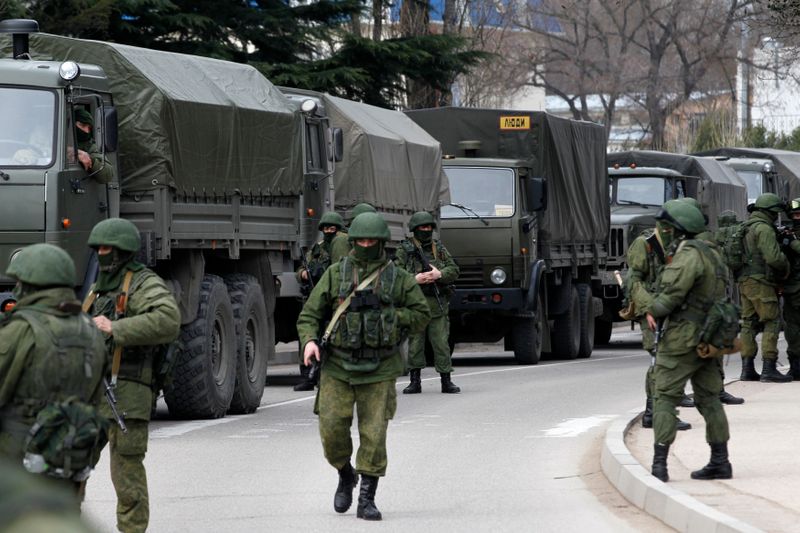 &copy; Reuters. Armed servicemen wait near Russian army vehicles outside a Ukrainian border guard post in the Crimean town of Balaclava March 1, 2014.   REUTERS/Baz Ratner 