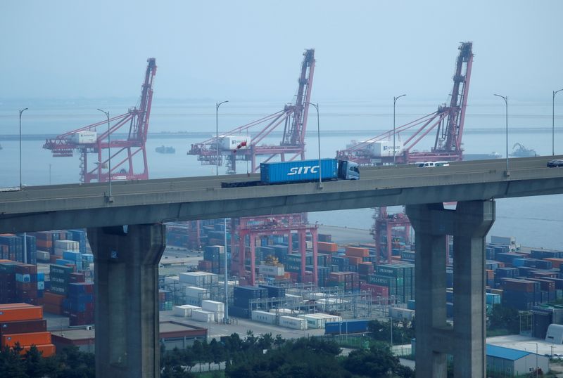 &copy; Reuters. FILE PHOTO: A truck carrying a shipping container travels past cranes at Pyeongtaek port in Pyeongtaek, South Korea, July 9, 2020. REUTERS/Kim Hong-Ji/File Photo
