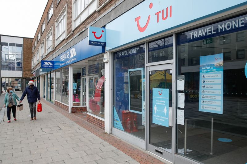 &copy; Reuters. FILE PHOTO: Two people walk past the TUI travel centre, amid the coronavirus disease (COVID-19) outbreak, in Hemel Hempstead, Britain, March 24, 2021. REUTERS/Paul Childs