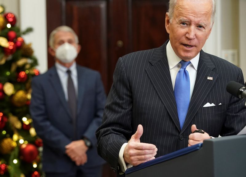 © Reuters. Dr. Anthony Fauci listens as U.S. President Joe Biden delivers an update on the Omicron variant at the White House in Washington, U.S., November 29, 2021. REUTERS/Kevin Lamarque     