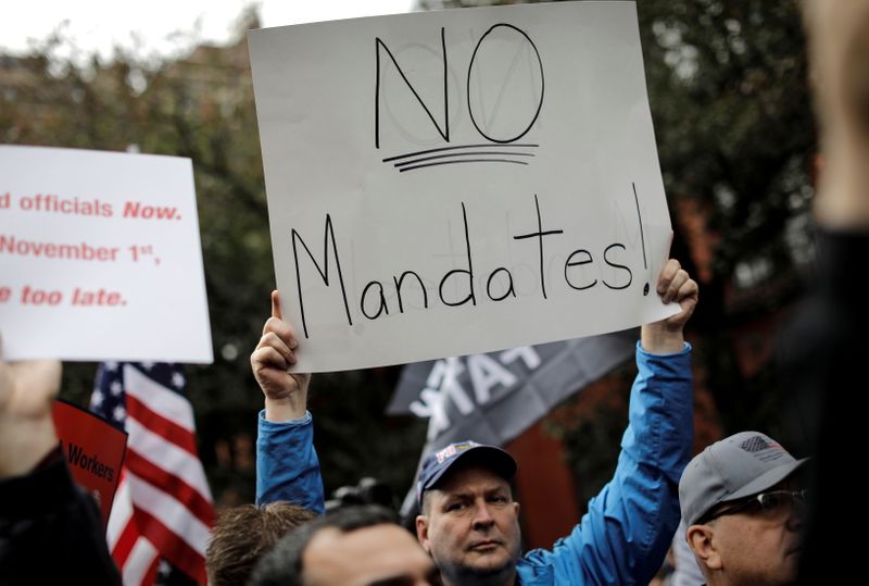 &copy; Reuters. FILE PHOTO: A demonstrator holds a sign during a protest by New York City Fire Department (FDNY) union members, municipal workers and others, against the city's COVID-19 vaccine mandates on Manhattan's Upper East Side, in New York City, New York, U.S., Oc