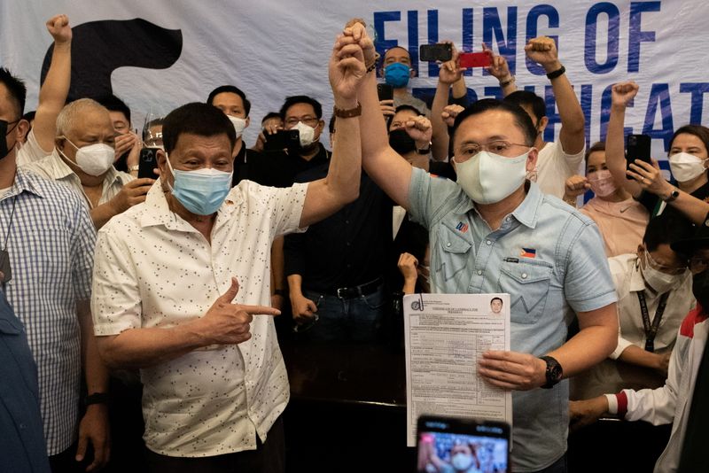 &copy; Reuters. FILE PHOTO: Philippine President Rodrigo Duterte raises the hand of Philippine Senator Christopher "Bong" Go after filing his certificate of candidacy for president for the 2022 national election, at the Commission on Elections, in Manila, Philippines, No