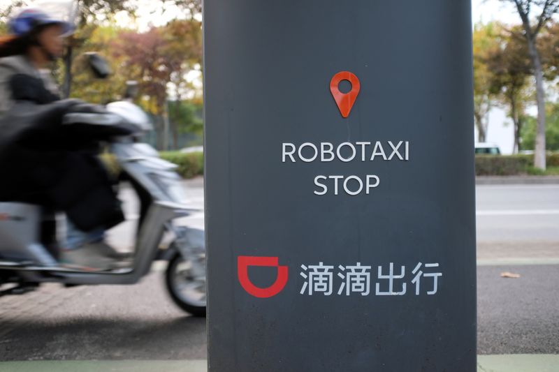&copy; Reuters. 　１１月３０日、中国交通運輸省は、配車サービス業界のドライバーの権利保護に向け新たなルールの概要を発表した。企業側に社会保険の提供と利益の公開を求めた。滴滴の看板、上海で