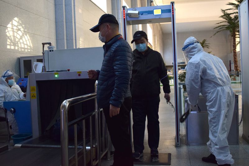 © Reuters. Passengers wearing face masks go through security screening at the Suifenhe railway station, following an outbreak of the coronavirus disease (COVID-19), in Suifenhe, a city bordering Russia in China's Heilongjiang province, April 17, 2020. Picture taken April 17, 2020. REUTERS/Huizhong Wu