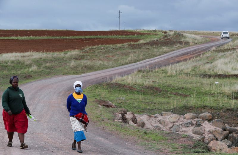 © Reuters. Women walk on a dirt road while using a handkerchief to cover their nose, as the new coronavirus variant, Omicron spreads, in Qumanco village in the Eastern Cape province of South Africa, November 30, 2021. REUTERS/Siphiwe Sibeko