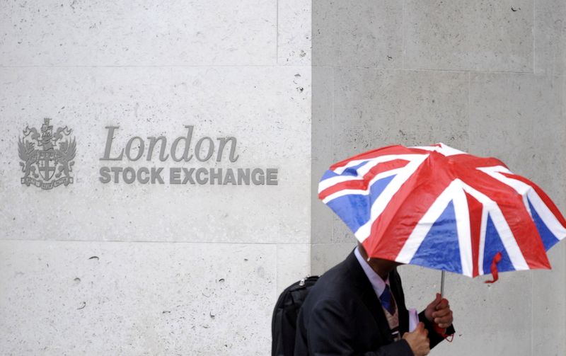 © Reuters. FILE PHOTO: A worker shelters from the rain under a Union Flag umbrella as he passes the London Stock Exchange in London, Britain, October 1, 2008.  REUTERS/Toby Melville/File Photo