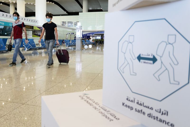 &copy; Reuters. مسافران يضعان كمامتين ويسيران داخل مطار الرياض الدولي يوم 31 مايو أيار 2021. تصوير: أحمد يسري -  رويترز.

