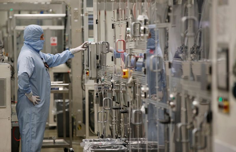 &copy; Reuters. FILE PHOTO: A worker in a protective suit operates a machine inside the Envision battery manufacturing plant at Nissan's Sunderland factory, Britain, July 1, 2021. REUTERS/Phil Noble/File Photo