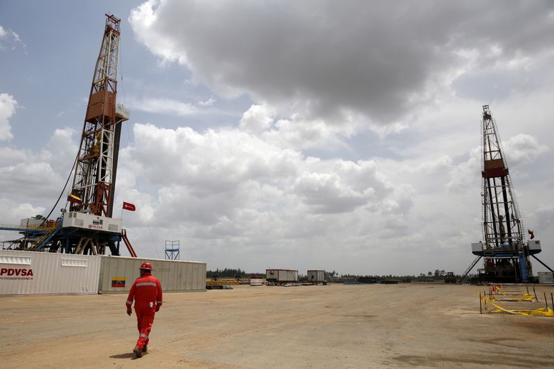 &copy; Reuters. Un operaio cammina accanto alle piattaforme di perforazione in un pozzo di petrolio gestito dalla compagnia petrolifera statale venezuelana PDVSA, nel bacino dell'Orinoco. 16 aprile 2015 REUTERS/Carlos Garcia Rawlins