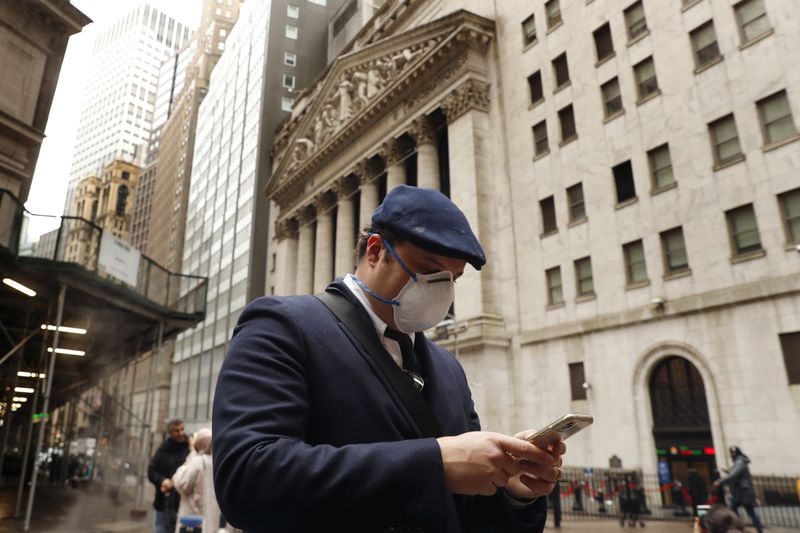 &copy; Reuters. A man wears a protective mask as he walks past the New York Stock Exchange on the corner of Wall and Broad streets during the coronavirus outbreak in New York City, New York, U.S., March 13, 2020. REUTERS/Lucas Jackson