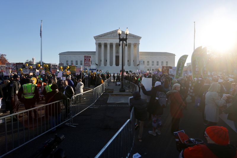 © Reuters. Anti-abortion and pro-abortion rights activists are separated by a barrier as they protest outside the Supreme Court building, ahead of arguments in the Mississippi abortion rights case Dobbs v. Jackson Women's Health, in Washington, U.S., December 1, 2021. REUTERS/Jonathan Ernst