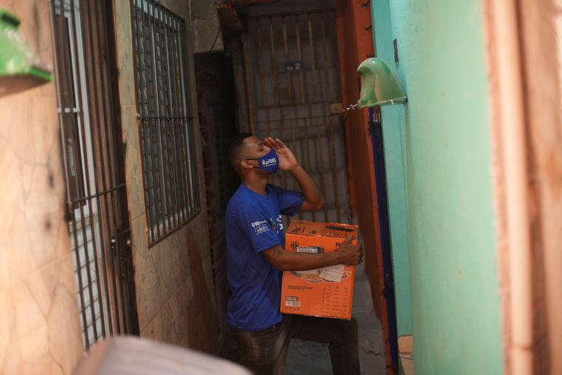 &copy; Reuters. Un miembro del Favela Brasil Express lleva un paquete en el barrio de Paraisopolis en Sao Paulo, Brasil, el 22 de octubre de 2021. REUTERS / Leonaro Benassatto