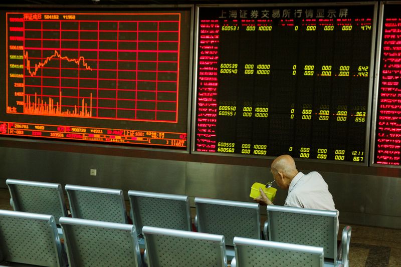 © Reuters. A man sits in front of a board showing market information at a securities brokerage house in Beijing, China August 5, 2019. REUTERS/Thomas Peter/File Photo