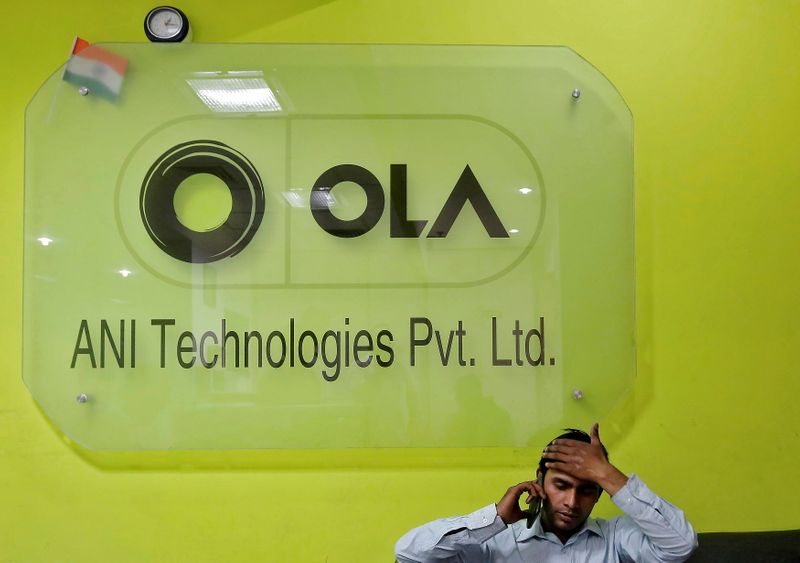 © Reuters. FILE PHOTO: An employee speaks over his phone as he sits at the front desk inside the office of Ola cab service in Gurugram, previously known as Gurgaon, on the outskirts of New Delhi, India, April 20, 2016.  REUTERS/Anindito Mukherjee/File Photo