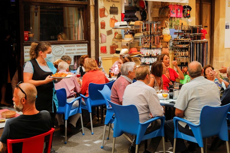 &copy; Reuters. Una camarera sirve comida a los clientes en la terraza de un bar en el centro de Ronda