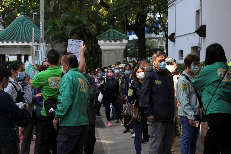 &copy; Reuters. People wearing face masks line up outside a community vaccination centre to receive a dose of Sinovac Biotech's CoronaVac COVID-19 vaccine in Hong Kong, China December 2, 2021. REUTERS/Lam Yik