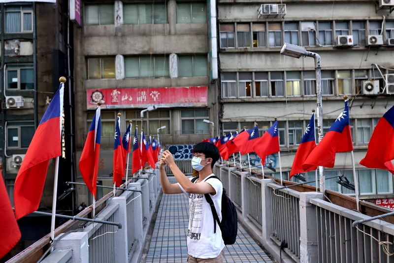 &copy; Reuters. FILE PHOTO: A man takes photos on an overpass decorated with Taiwan flags ahead of upcoming National Day celebrations in Taipei, Taiwan, October 7, 2021. REUTERS/Ann Wang