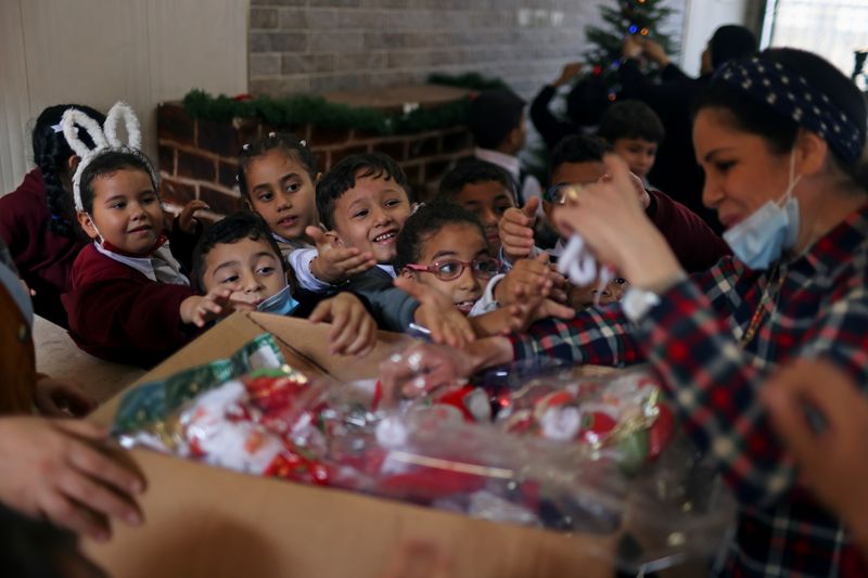 &copy; Reuters. A teacher hands out to students Christmas-themed gifts at Rosary Sisters' School in Gaza City, November 24, 2021. Picture taken November 24, 2021. REUTERS/Mohammed Salem