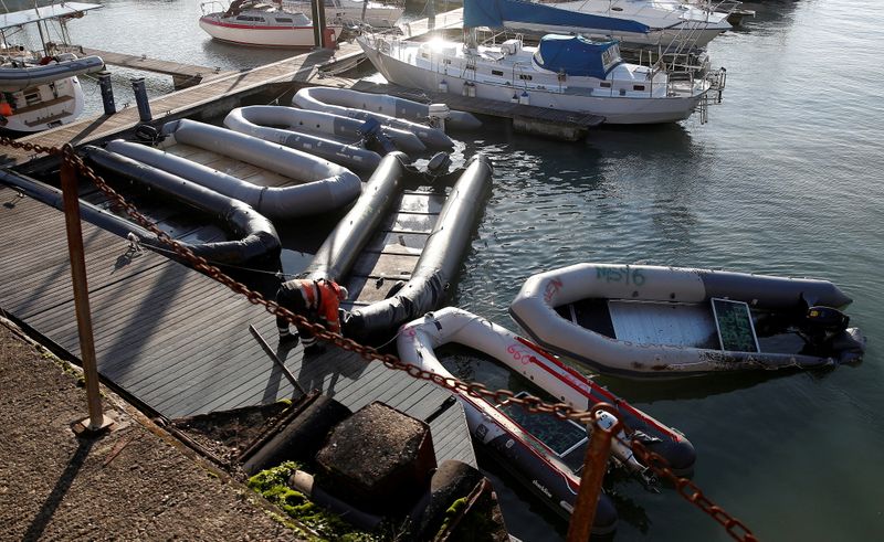 &copy; Reuters. FILE PHOTO: Inflatable boats used by migrants who crossed the English Channel from France, are secured by a Port of Dover official in the marina in Dover, Britain, November 29, 2021.  REUTERS/Peter Nicholls//File Photo