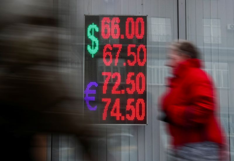 &copy; Reuters. People walk next to a window with a board, showing the currency exchange rates of the Euro and the U.S. dollar against the Russian rouble, on a street in Moscow, Russia February 28, 2020.REUTERS/Evgenia Novozhenina