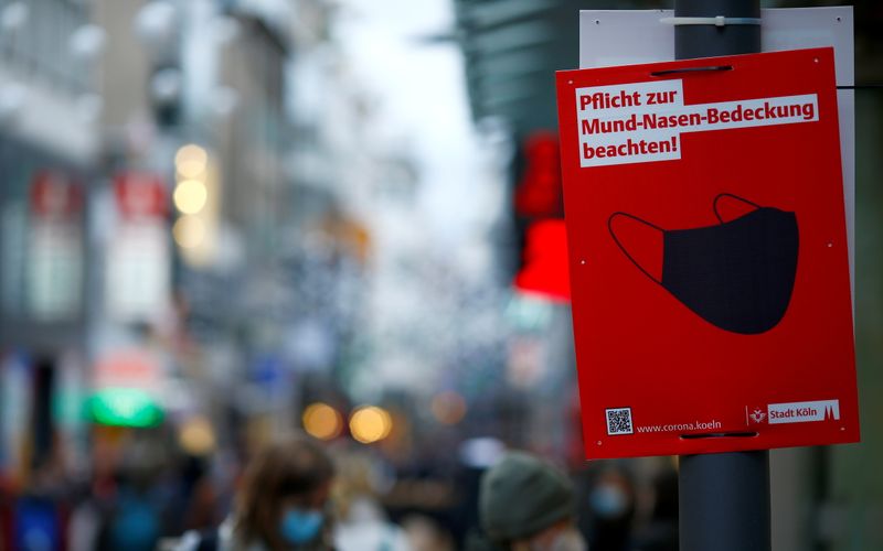 &copy; Reuters. FILE PHOTO: A sign that reads "Observe the obligation to cover your mouth and nose" is placed on Hohe Strasse shopping street as the spread of the coronavirus disease (COVID-19) continues in Cologne, Germany, December 1, 2021. REUTERS/Thilo Schmuelgen
