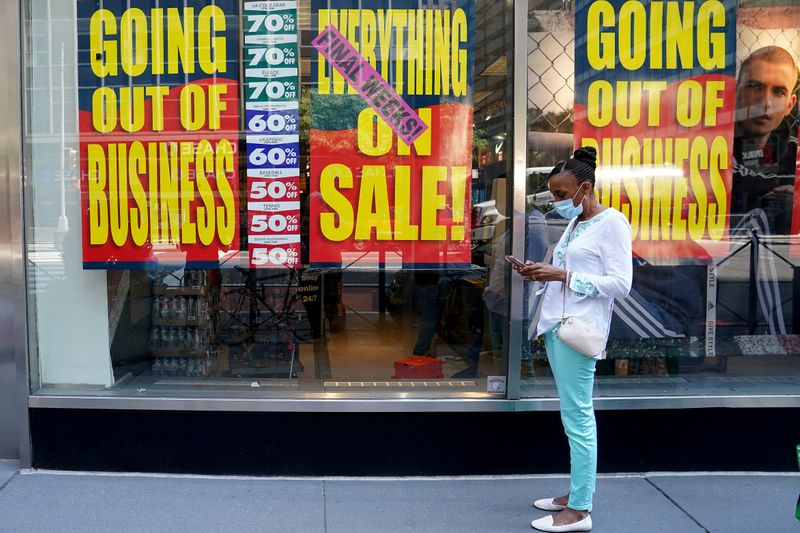 &copy; Reuters. FILE PHOTO: People walk past a business that is closing following the outbreak of the coronavirus disease (COVID-19) in the Manhattan borough of New York City, New York, U.S., August 17, 2020. REUTERS/Carlo Allegri//File Photo