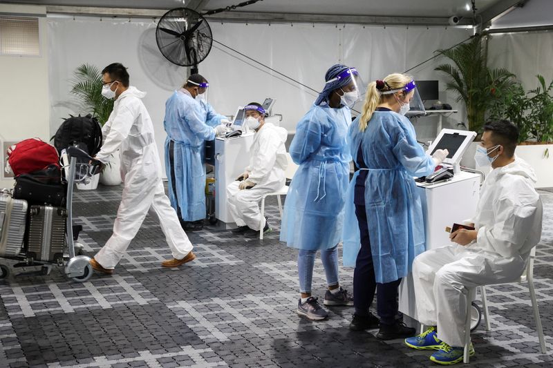 &copy; Reuters. FILE PHOTO: Travellers receive tests for the coronavirus disease (COVID-19) at a pre-departure testing facility, as countries react to the new coronavirus Omicron variant, outside the international terminal at Sydney Airport in Sydney, Australia, November