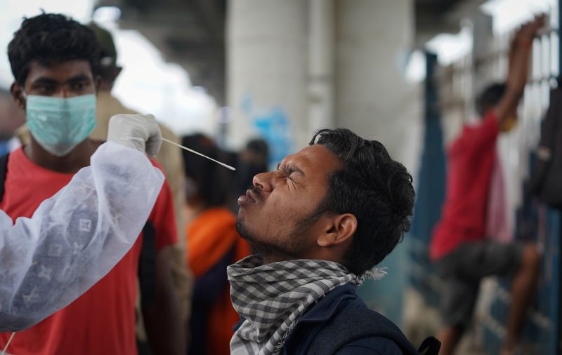 &copy; Reuters. Un trabajador sanitario con equipo de protección personal (EPP) recoge una muestra de hisopo de un hombre durante una campaña de pruebas rápidas de antígeno para la enfermedad del coronavirus (COVID-19), en una estación de tren en Mumbai, India, 1 de