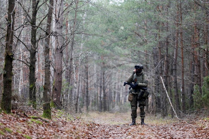 &copy; Reuters. FILE PHOTO: A military stands guard in the woods, close to the Milejczyce village, Poland, November 26 2021. REUTERS/Lukasz Glowala/File Photo