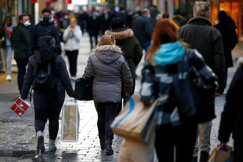 &copy; Reuters. FILE PHOTO: People carry bags on Hohe Strasse shopping street as the spread of the coronavirus disease (COVID-19) continues in Cologne, Germany, December 1, 2021. REUTERS/Thilo Schmuelgen