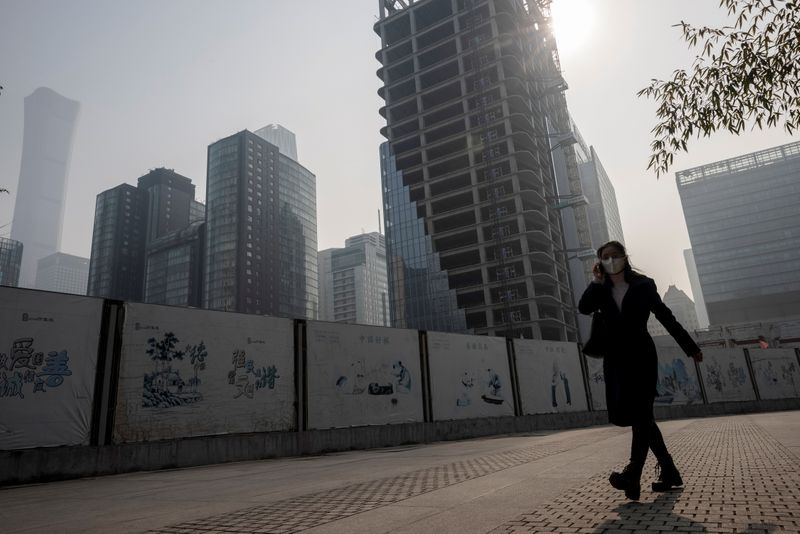 &copy; Reuters. FILE PHOTO: A woman walks in the Central Business District (CBD) on a hazy morning in Beijing, China, October 25, 2021.   REUTERS/Thomas Peter